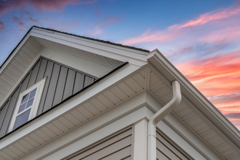 White,Frame,Gutter,Guard,System,,With,Gray,Horizontal,And,Vertical Siding of a house