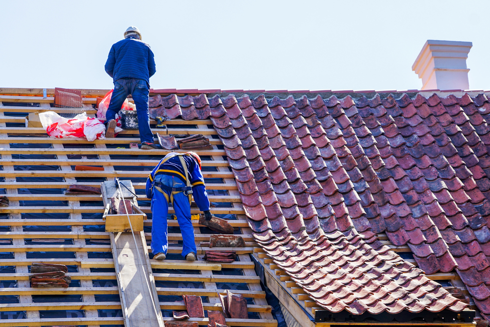 Roof contractor working on roof replacement in a house in Kansas city, ks