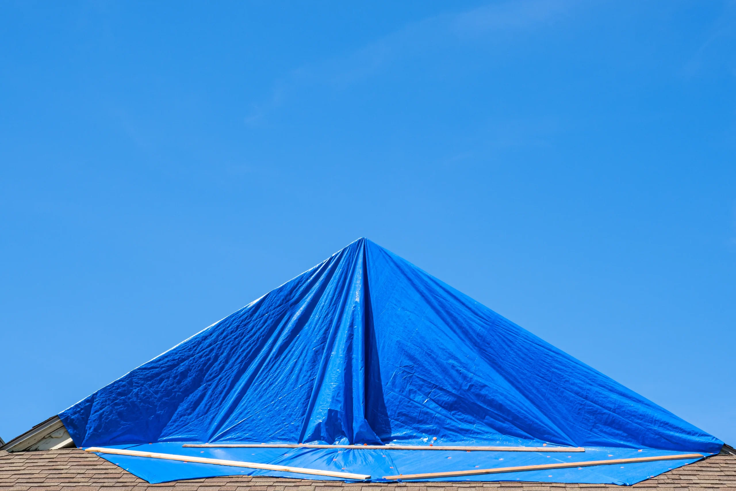Blue tarp protecting hurricane damaged roof.