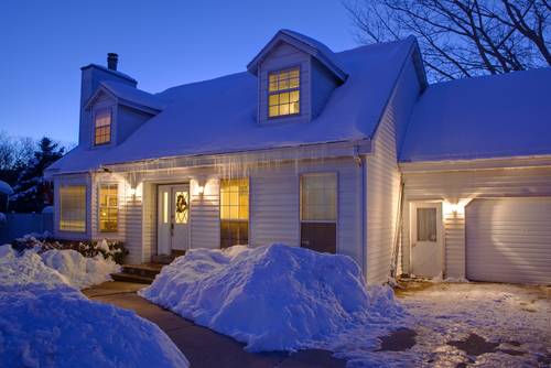 Typical American home with icy winter snow - evening twilight - cape cod style
